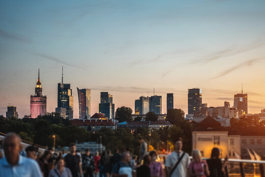 sunset over skyline of Warsaw city with skyscrapers and downtown district, crowd of people walking, tourist travel destination, rush hour in capital of Poland 4k, vertical video footage