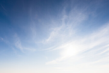 A serene image showcasing a clear blue sky adorned with soft, wispy clouds