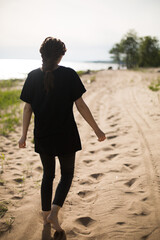 Young Woman Walking on a Sandy Beach