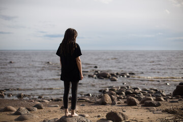 Young Woman Walking on Rocks at the Beach
