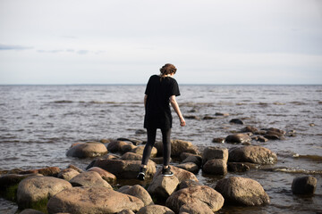 Young Woman Walking on Rocks at the Beach
