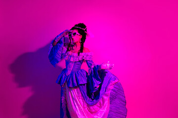 Elegant woman in royal-style dress under purple neon lighting showcasing vintage glamour