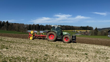 Tractor plowing agricultural field on sunny day