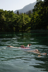 Young Woman Swimming in a Crystal-Clear Alpine Lake