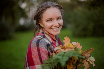 Woman with Dreadlocks Holding Autumn Leaves