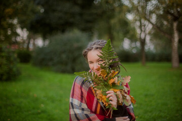 Woman with Dreadlocks Holding Autumn Leaves