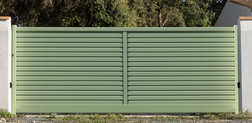 Portail en aluminium de couleur verte d'une maison	