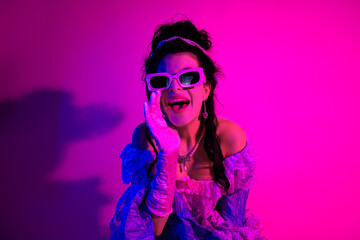 Elegant girl in vintage dress with modern sunglasses and vibrant ultraviolet lighting