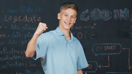 Handsome adult standing at blackboard with engineering code or prompt while attend in STEM class....