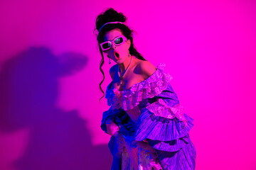 Elegant young woman in vintage royal dress with neon light theme showcasing modern yet historic fashion