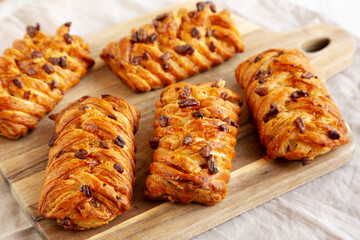 Homemade Maple Pecan Danish Pastry on a wooden board, side view.