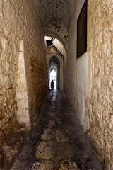 Fototapeta premium Scenic view of Ostuni, Italy's 'White City,' showcasing whitewashed buildings under a clear blue sky, with narrow streets and historic architecture illuminated by sunlight.