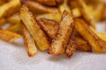 Golden crispy potato wedges sprinkled with sea salt, close-up. Perfect comfort food concept, perfect for fast food menus, advertising and food blogs, selective focus