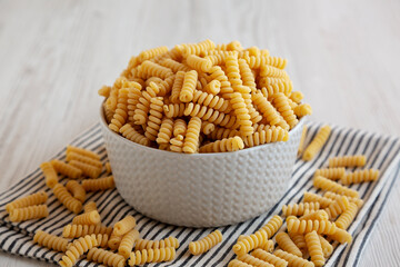 Uncooked Organic Dry Fusilli Pasta in a Bowl, side view.