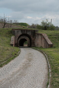 Cobbled path leads through a brick tunnel in Petrovaradin Fortress, Novi Sad, Serbia. Captured in 2025, this historic military passageway evokes travel, history, and timeless architecture.