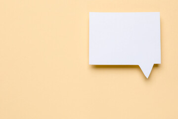 Blank speech bubble on beige background, top view. Space for text