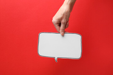 Woman holding blank speech bubble on red background, closeup. Space for text
