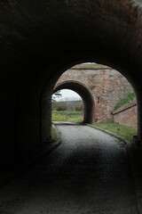 Cobbled path framed by historic arches at Petrovaradin Fortress in Novi Sad, Serbia. Taken in 2025, this photo highlights symmetry, depth, and the blend of light and shadow in old architecture.