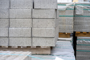 View of stacked gray paving slabs on a wooden pallet at a construction site