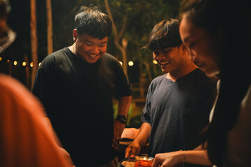 Asian people Enjoying Summer BBQ Party, Cooking Delicious Meat Grill for Friends, Sharing Fun and Happy Moments Together, Embracing a Lifestyle of Friendship Dinner at Night