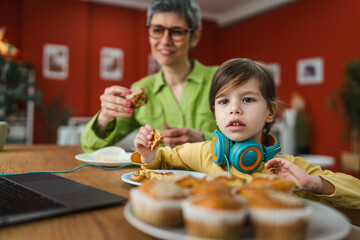 cute little girl enjoy while watch cartoon on laptop with her grandma