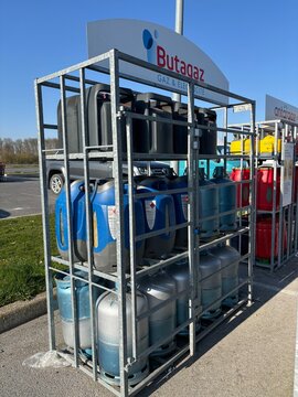 bouteilles de gaz de marque butagaz dans le pr&eacute;sentoir en m&eacute;tal sur un parking de magasin