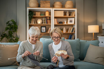 Senior women knitting and embroidering together at home