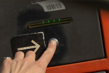 A hand is pressing a button on a public dropbox that has green indicator lights, showing its function