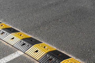 Próg zwalniający na asfalcie z żółto-czarnym wzorem funkcjonalność miejskiej infrastruktury © Kacper
