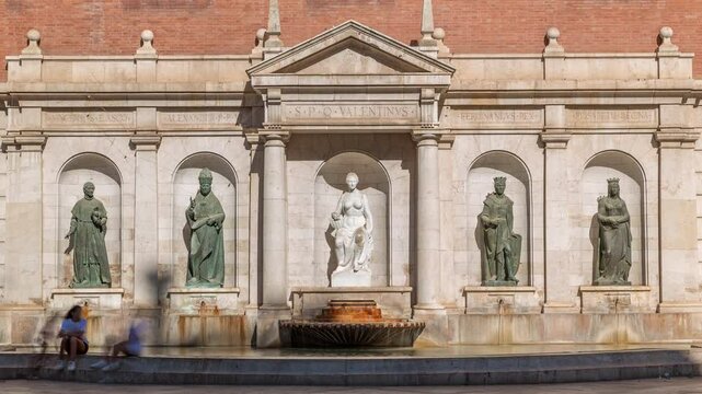Patriarch's College Square in Valencia timelapse, featuring the fountain with sculptures. Shadow covering during sunny day. Classic architecture, Spain.