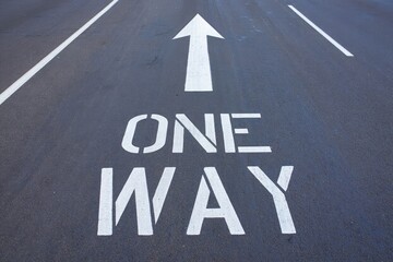 One way arrow painted on street.