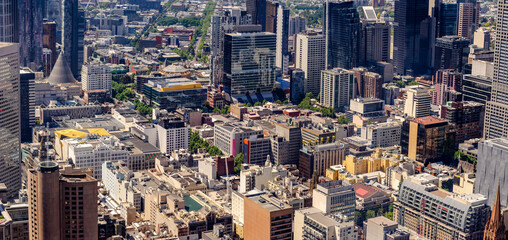 Panoramic aerial view of Melbourne, Australia, with a mix of gleaming skyscrapers and mid-rise...