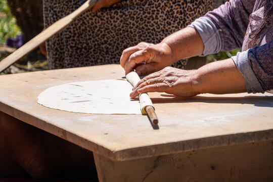 Close up of traditional Turkish dough being rolled with a rolling pin