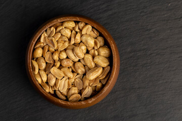peeled and roasted peanuts in a wooden round bowl