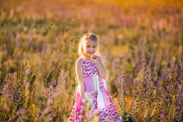 Smiling Girl in Pink Floral Dress in Blooming Meadow