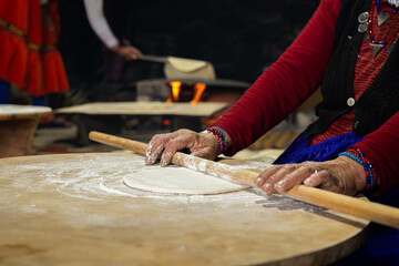 Elderly Turkish woman rolling dough to make traditional bread , hand detail