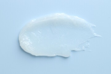 Moisturizing lip balm on light blue background, top view