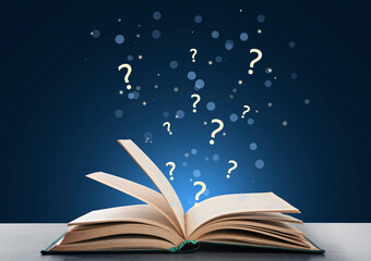 Question marks flying out from open book on wooden table against dark blue background, bokeh effect