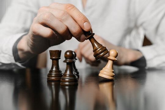 Close-up of male hand moving chess piece on board. Strategic decision making during intense game. Concept of planning, logic, competition, and intellectual challenge.