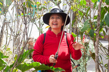 A woman wearing a hat is actively engaging in the exploration of nature and its wonders