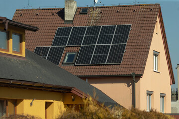 Fototapeta premium The installation of solar energy panels on a residential rooftop located in a suburban area