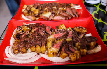 Juicy Beef Slices Topped with Sautéed Onions on Platter