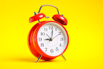 One red alarm clock on yellow background