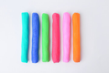 Different colorful play dough on white background, flat lay