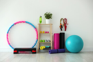 Different fitness equipment near white wall indoors