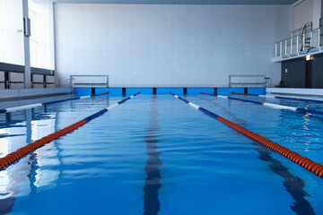 Swimming pool with clean water and lane dividers indoors