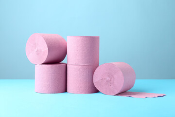 Pink toilet paper rolls on light blue background