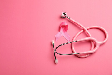 Fototapeta premium Breast cancer awareness. Pink ribbon and stethoscope on color background, flat lay. Space for text