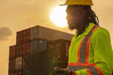 African logistics workers man cheking on site area operations at a busy shipping container yard at...