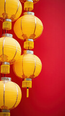 Obraz premium A row of yellow lanterns hanging from a red background. The lanterns are hanging in a line and are all the same size